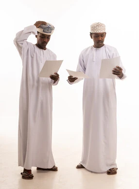 Omani Men in Traditional Dress Reviewing Documents