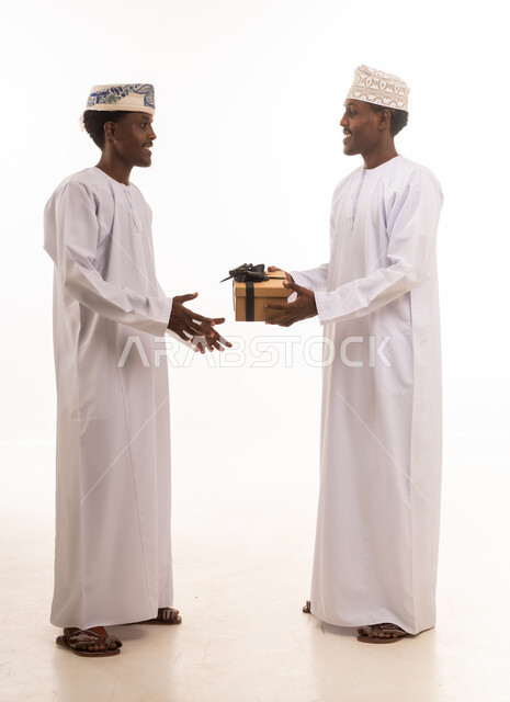 رجال عمانيون بالزي التقليدي يتبادلون صندوق هدايا