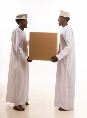 رجال عمانيون يحملون صندوق شحن بخلفية بيضاء