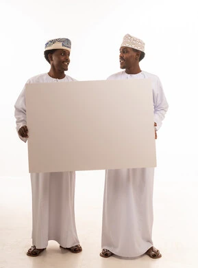 رجال عمانيون يحملون لوحة بيضاء فارغة للإعلانات