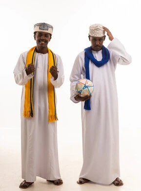 رجال عمانيون بالزي التقليدي مع كرة قدم