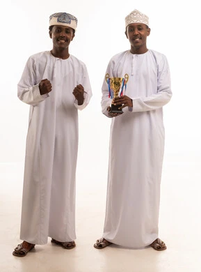 رجال عمانيون يحتفلون بكأس ذهبي في الاستوديو