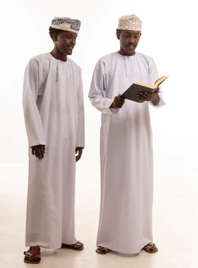 رجال عمانيون يقرأون كتاباً بالزي التقليدي بخلفية بيضاء