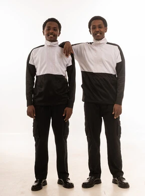 رجلان عمانيان بملابس رياضية بيضاء وسوداء بخلفية بيضاء