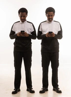 رجلان عمانيان يستخدمان الهواتف الذكية على خلفية بيضاء