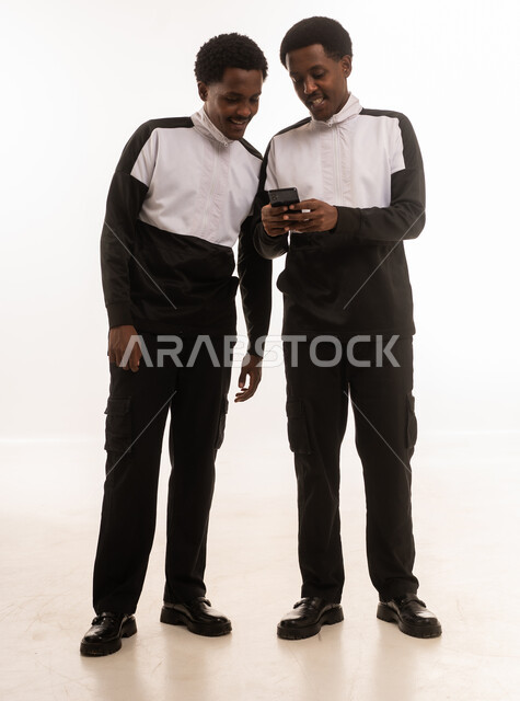 رجلان عمانيان يستخدمان الهاتف الذكي بخلفية بيضاء