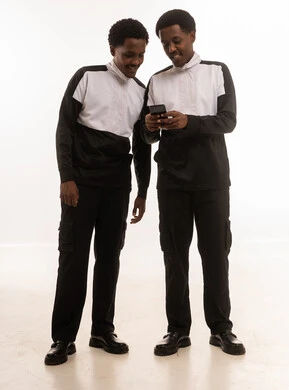 رجلان عمانيان يستخدمان الهاتف الذكي بخلفية بيضاء