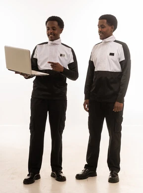 رجال عمانيون مع حاسوب محمول بخلفية بيضاء