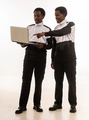 رجال عمانيون ينظرون إلى لابتوب على خلفية بيضاء