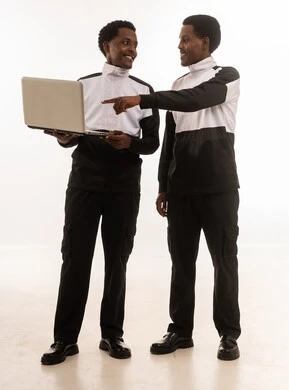 رجال عمانيون يناقشون العمل على لابتوب بزي موحد