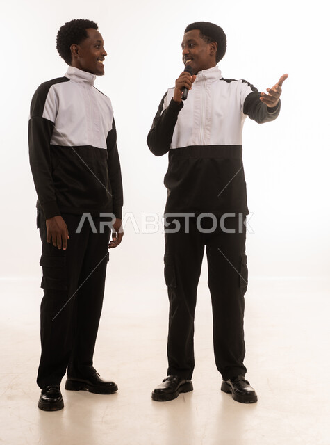 Omani Men in Sportswear Speaking into Microphone