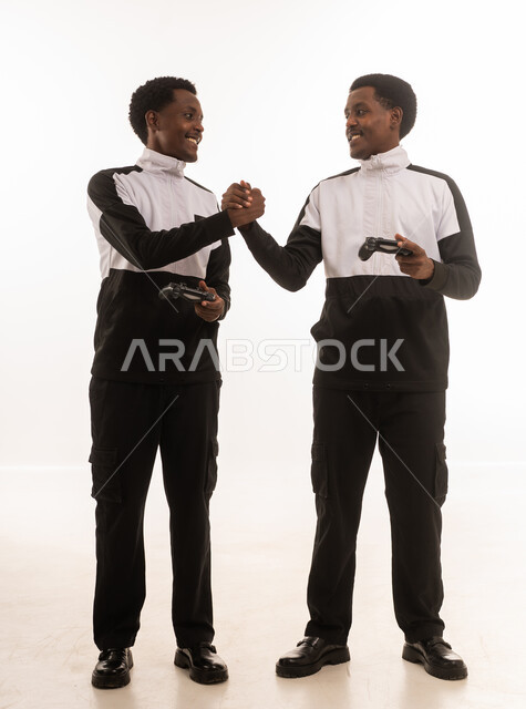Omani Men Gaming with Controllers and Handshaking