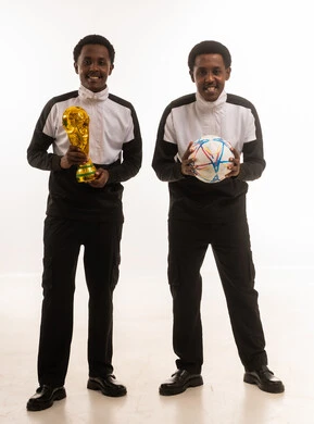 رجال عمانيون مع كرة قدم وكأس ذهبي