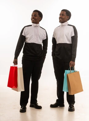 رجال عمانيون يحملون أكياس تسوق أمام خلفية بيضاء