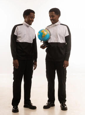 رجال عمانيون ينظرون إلى مجسم الكرة الأرضية بخلفية بيضاء