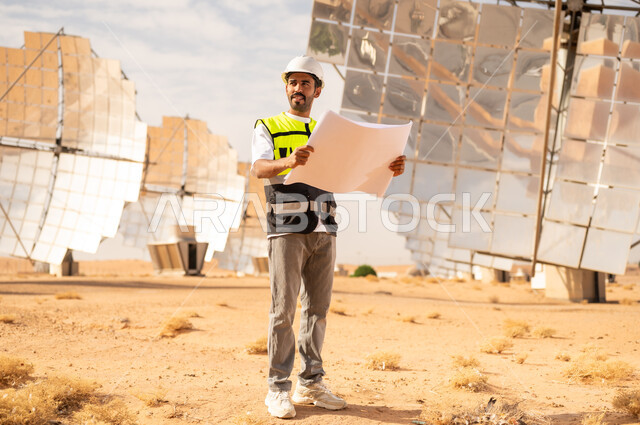 مهندس عربي في محطة طاقة شمسية مع مخطط هندسي