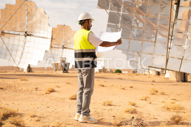 مهندس سعودي يتفحص المخططات في محطة طاقة شمسية