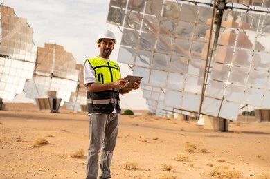 Saudi Engineer at Solar Power Plant with Tablet