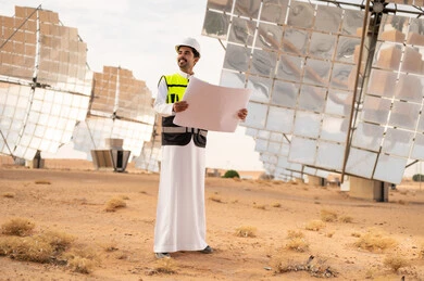 Saudi Engineer at Solar Power Plant with Blueprint