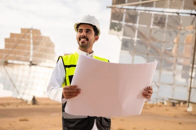 Saudi Engineer at Solar Power Plant with Blueprint