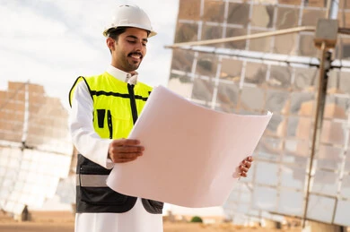 Saudi Engineer at Solar Power Plant with Blueprints