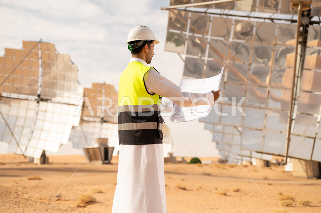 Saudi Engineer at Solar Power Plant with Blueprints