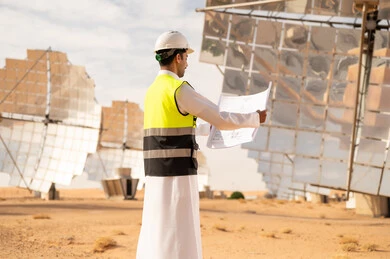 Saudi Engineer at Solar Power Plant with Blueprints
