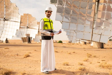 Saudi Engineer at Solar Power Plant with Blueprints