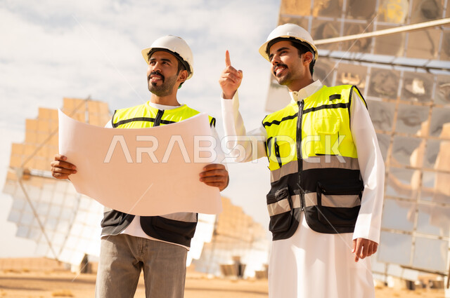 مهندسون عرب في محطة طاقة شمسية مع مخططات هندسية
