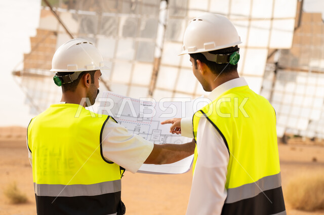 مهندسون عرب في محطة طاقة شمسية مع مخطط فني