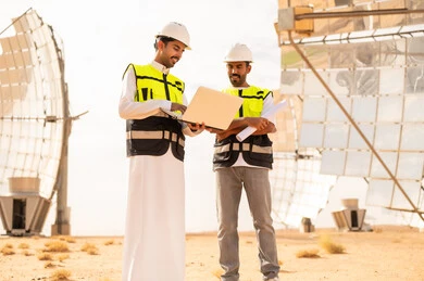 مهندسون عرب في محطة طاقة شمسية مع كمبيوتر محمول