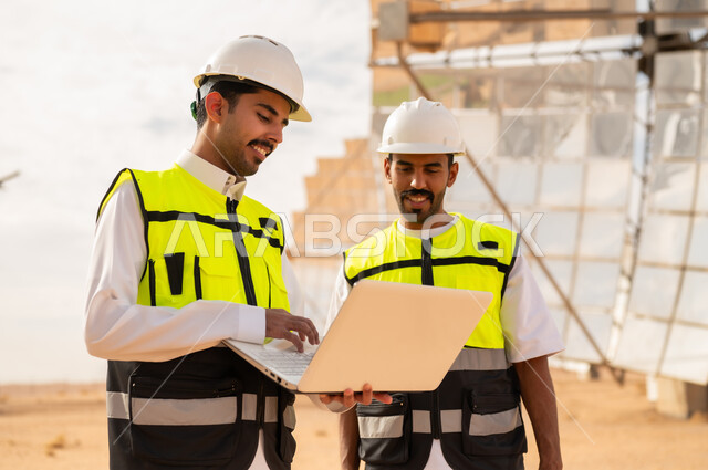 مهندسون سعوديون مع كمبيوتر محمول في محطة طاقة شمسية