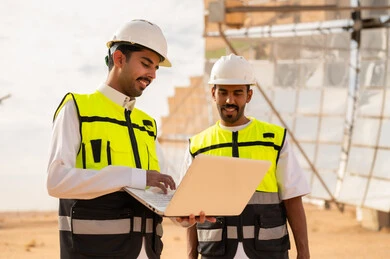 مهندسون سعوديون مع كمبيوتر محمول في محطة طاقة شمسية