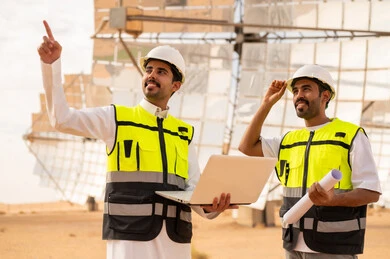 مهندسون عرب في محطة طاقة شمسية مع لابتوب