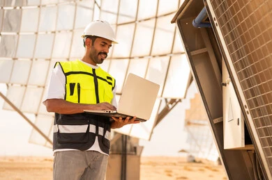 مهندس سعودي يستخدم كمبيوتر محمول في محطة طاقة شمسية
