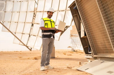 مهندس سعودي في محطة طاقة شمسية مع كمبيوتر محمول