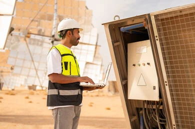 Saudi Engineer Inspecting Solar Power Station with Laptop