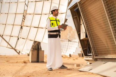 مهندس سعودي يتفحص الألواح الشمسية في الصحراء