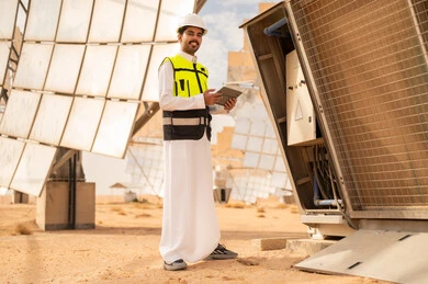 مهندس سعودي مع جهاز لوحي في محطة طاقة شمسية