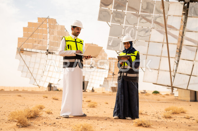 مهندسون سعوديون يعملون في محطة طاقة شمسية بالصحراء