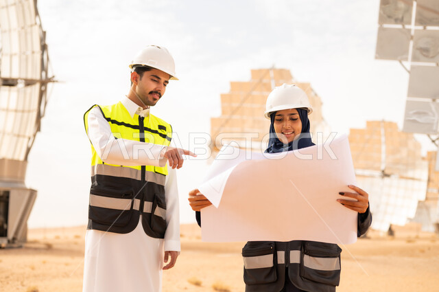 مهندسون سعوديون يراجعون مخططات في محطة طاقة شمسية