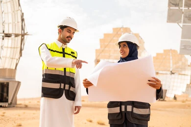 مهندسون سعوديون في محطة طاقة شمسية مع المخططات