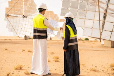 Saudi Engineers at Solar Power Station with Blueprints
