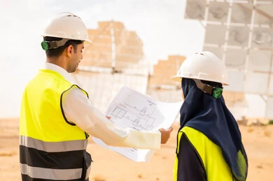 مهندسون سعوديون يراجعون مخططات في محطة طاقة شمسية
