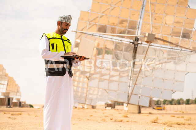 مهندس عماني في محطة طاقة شمسية مع كمبيوتر