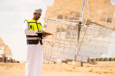Omani Engineer at Solar Power Plant with Laptop
