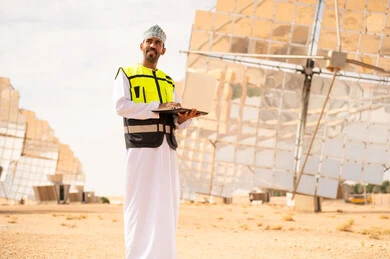 Omani Engineer with Laptop at Solar Power Plant