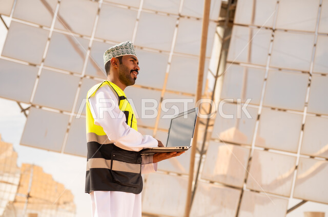 Omani Engineer with Laptop at Solar Power Plant