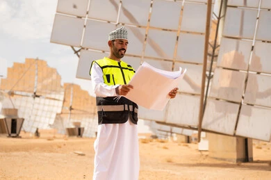Omani Engineer at Solar Power Plant Holding Blueprints
