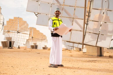 Omani Engineer with Blueprints at Solar Power Plant